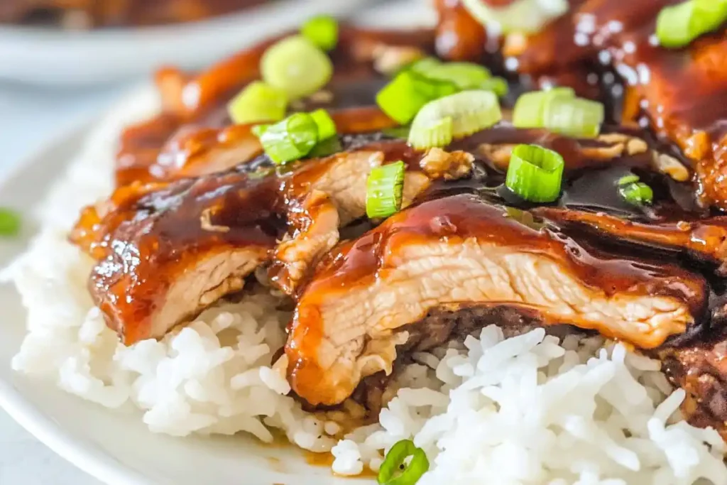 Sliced Hawaiian Teriyaki Chicken served over rice and garnished with green onions.